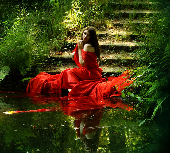 Femeie pe malul apei, purtând roşu